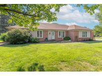 Charming brick home featuring a well-manicured lawn, bright windows, and a welcoming front entrance at 425 Saddle Hill Ct, Indianapolis, IN 46234