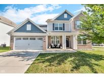 Charming two-story home with brick and siding exterior, complemented by a well-manicured lawn and attached garage at 5353 Hibiscus Dr, Plainfield, IN 46168