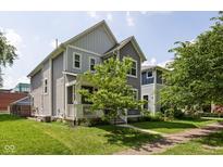 Two-story home showcasing well-maintained landscaping and a charming covered front porch at 630 Dorman St, Indianapolis, IN 46202