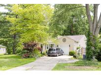 Charming beige home with a one car garage and a well-maintained lawn at 6379 Monitor Dr, Indianapolis, IN 46220