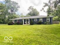 Ranch style home featuring a well-manicured lawn and cozy front porch at 6546 Derbyshire Rd, Indianapolis, IN 46227