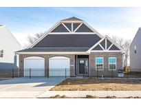 Charming single-story home with a two-car garage and a well-maintained brick facade at 2057 Abbey Ln, Columbus, IN 47201