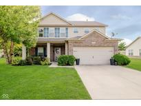 Charming two-story home with a well-manicured lawn and attached two-car garage at 20846 Winding Lake E Dr, Noblesville, IN 46062