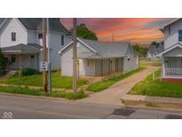 Charming single-story home featuring a welcoming front porch and well-maintained lawn at sunset at 2111 Central Ave, Anderson, IN 46016