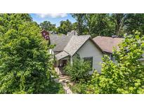 Charming home with a welcoming front porch, surrounded by lush greenery and mature trees at 2426 Lasalle St, Indianapolis, IN 46218