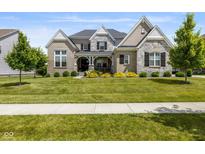Charming two-story home featuring stone accents, a landscaped yard, and inviting front porch at 2566 Maple Creek Dr, Westfield, IN 46074