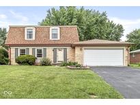 Charming brick home featuring a well-maintained lawn and two-car attached garage at 3224 Prague Rd, Indianapolis, IN 46227