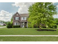 Lovely two-story brick home with a well-maintained lawn and mature trees at 4150 Huntsman Dr, Zionsville, IN 46077