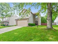 Charming two-story home featuring manicured front lawn, attached garage, and inviting curb appeal at 5541 Lippan Way, Indianapolis, IN 46221