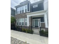 Charming two-story townhome with brick and vinyl siding, black iron fence, sidewalk and front yard at 9215 Hawley Dr, Indianapolis, IN 46216