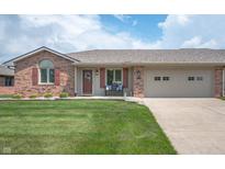 Charming single-story brick home featuring a well-maintained lawn and attached two-car garage at 114 Asbury Dr, Anderson, IN 46013