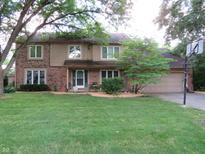 Charming two-story home with a brick facade, well-maintained lawn, and mature trees at 1327 Goldfinch Dr, Carmel, IN 46032