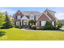 Beautiful two-story brick home with well-manicured lawn and professional landscaping at 3711 Pete Dye Blvd, Carmel, IN 46033