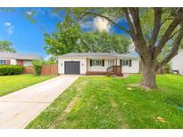 Charming single-story home featuring a well-maintained lawn, attached garage, and inviting front porch at 5512 Lunsford Dr, Indianapolis, IN 46237