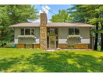 Charming home featuring a stone chimney, flower boxes, and well-maintained lawn at 6254 Grosbeak Ct, Nineveh, IN 46164