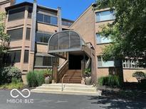 Well-maintained condo building with elegant covered entrance and manicured landscaping at 8577 One W Dr # 301, Indianapolis, IN 46260