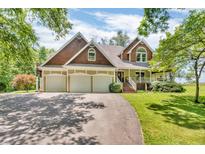 Inviting home with a three-car garage, front porch, mature trees, and a winding driveway at 940 S County Road 200 W, Danville, IN 46122