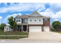 Beautiful two-story home with brick and gray siding, complemented by a lush green lawn and two-car garage at 1266 Hamilton Dr, Greenwood, IN 46143
