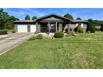 Charming single-story home with a covered porch, an American flag, and a beautifully landscaped front yard at 474 N Kristi Rd, Martinsville, IN 46151
