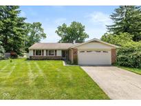 Charming single-story home with a well-manicured lawn and attached two-car garage at 6623 Lakeknoll Dr, Indianapolis, IN 46220