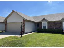 Charming home with a two-car garage, neat landscaping and green lawn on a sunny day at 7259 Registry Dr, Indianapolis, IN 46217