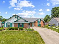 Charming single-story home with a brick and vinyl exterior, well-manicured lawn, and a curved driveway at 7384 Southern Lakes Dr, Indianapolis, IN 46237