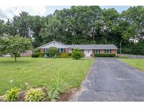 Charming single-story home featuring manicured lawn and mature trees offering great curb appeal at 7780 Cree Trl, Indianapolis, IN 46250