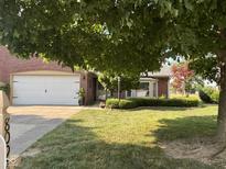 Charming brick home with a two-car garage and a well-manicured lawn, shaded by a mature tree at 8092 Crystal Ct, Avon, IN 46123