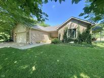 Charming single-story home with brick facade, mature trees, and a well-manicured lawn at 8829 Tracy Dr, Clayton, IN 46118
