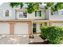 Charming townhome featuring an attached garage, green door, and well-maintained landscaping at 9689 Exchange St, Fishers, IN 46038