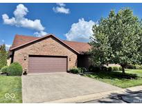 Charming brick home featuring an attached two-car garage and landscaped front yard at 3400 W Riggin Rd, Muncie, IN 47304