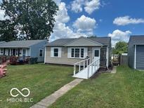 Charming single-story home with a ramp leading to the front door on a sunny day at 5332 Fletcher Ave, Indianapolis, IN 46219