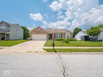 Charming brick home with a well-manicured front yard, beautiful landscaping, and an attached two-car garage at 5548 Glen Canyon Dr, Indianapolis, IN 46237