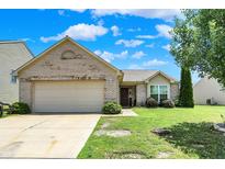 Charming one-story brick home with an attached two-car garage and well-maintained front yard at 6383 Enclave Blvd, Greenwood, IN 46143