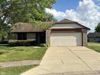 Charming single-story home with a two-car garage, stone accents, and a well-manicured lawn at 7313 Shanna Cir, Indianapolis, IN 46236