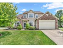 Charming two-story home featuring a brick and vinyl exterior, manicured lawn, and attached two-car garage at 793 Penny Ln, Pittsboro, IN 46167