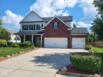 Traditional two-story home showcasing a brick and siding facade, two-car garage, and well-manicured landscaping at 8433 Vyners Ln, Avon, IN 46123