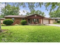 Charming single-story brick home with a well-manicured lawn and a cozy front porch at 3331 Loral Dr, Anderson, IN 46013