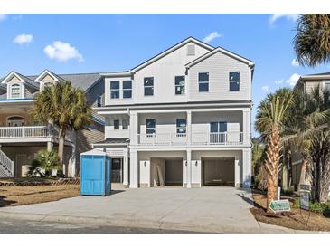 New construction home with a three-car garage, balcony, and white siding at 410 5Th Ave. S, North Myrtle Beach, SC 29582