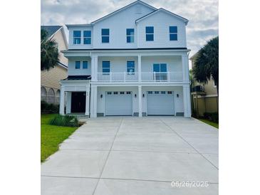 Stunning three-story white home with a charming balcony and a spacious two-car garage at 410 5Th Ave. S, North Myrtle Beach, SC 29582