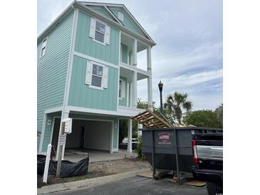 New construction with a two-story covered porch, pale blue siding, white trim and a drive-under garage at 1207 Salt Windy Way, North Myrtle Beach, SC 29582