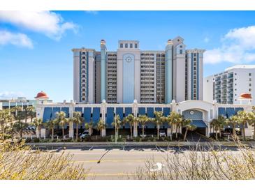 Beautiful condo building with underground parking, blue facade, and palm tree lined entrance at 2401 S Ocean Blvd. # 1156, Myrtle Beach, SC 29577