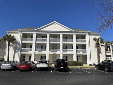 Attractive building with white pillars and ample parking on a clear, sunny day at 5020 Windsor Green Way # 103, Myrtle Beach, SC 29579