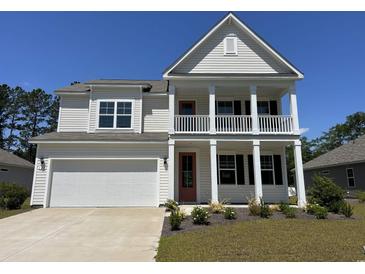 Charming two-story home with a double porch, white siding, and a well-manicured lawn at 120 Fair Meadow Ct., Loris, SC 29569