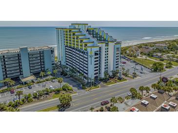 Coastal condo building featuring a unique yellow and white design with ocean views and a parking garage at 6804 N Ocean Blvd. # 1037, Myrtle Beach, SC 29572