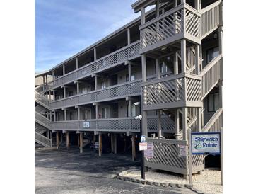 Exterior of condo shows elevated structure, wooden stairs, parking, and signage for Shipwatch Pointe at 9621 Shore Dr. # J-229, Myrtle Beach, SC 29572