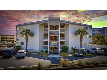 Beautiful condo complex with palm trees, multiple levels, and ample parking with a peek at the sunset in the background at 9600 Shore Dr. # A-102, Myrtle Beach, SC 29572
