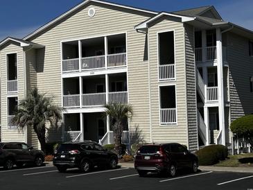 Inviting exterior view of a multi-story condo with balconies and well-maintained landscaping with convenient parking spaces at 220 Landing Rd. # I, North Myrtle Beach, SC 29582