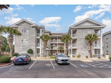Charming condo complex featuring stone facade, multiple floors, and ample parking for residents and guests at 4733 Wild Iris Dr. # 302, Myrtle Beach, SC 29577