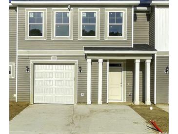 Charming townhome featuring a one-car garage and a covered front porch at 293 Sandridgebury Dr. # 66, Little River, SC 29566